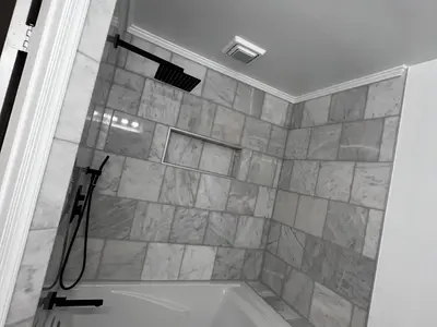 Tub-shower with marble tile and black hardware