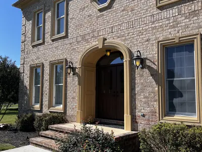Brick home entrance with arched doorway and lanterns