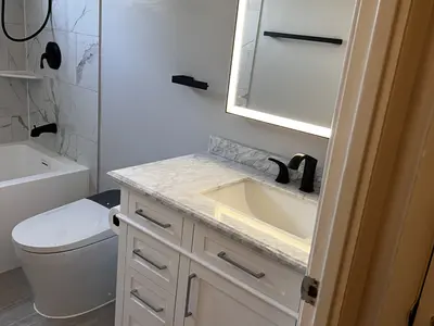 White vanity with LED mirror and marble countertop