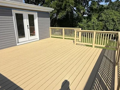 Finished tan composite deck with railings and backyard views
