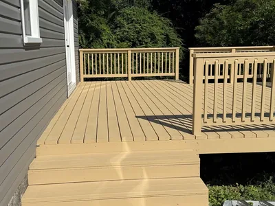 Finished composite deck with steps and railings on a remodeled home